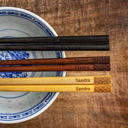 Three pairs of Japanese-style Chopsticks, Black wood, Dark wood and Light wood. Each pair is personalised with either a name or a phrase in English, translated into either Chinese or Japanese, and features a contemporary design at the end of the chopsticks.
