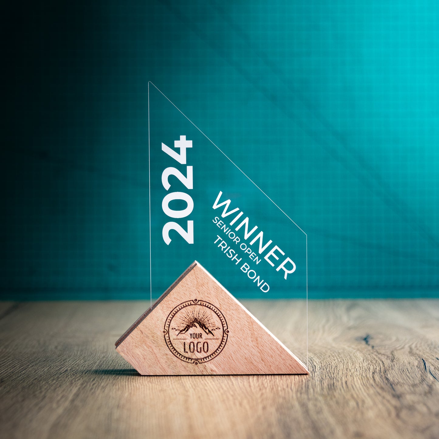 A Large Jib Award. An Eco-Friendly Wooden and Perspex Award that has a wooden base engraved with a logo and a recyclable clear Perspex triangular shape with a point on the right side of the trophy, which contains the winner and event information.