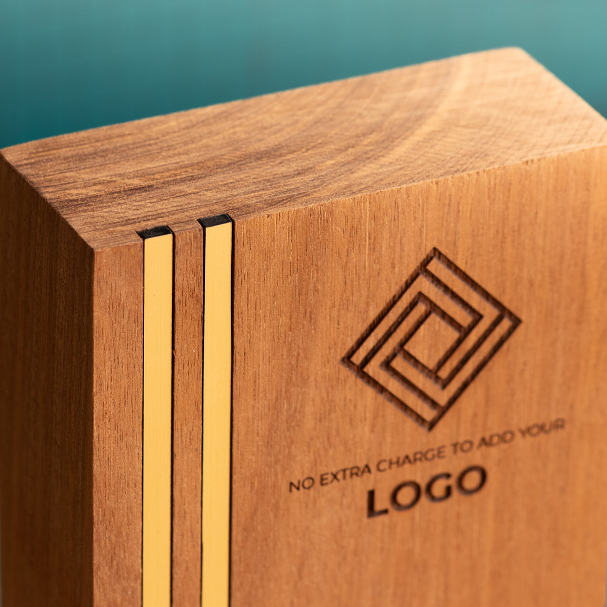 Close-up of the top-left corner of a Kingdom wooden trophy, showing two narrow gold metallic inlays running vertically through the wood and sitting flush with the front surface and top edge.