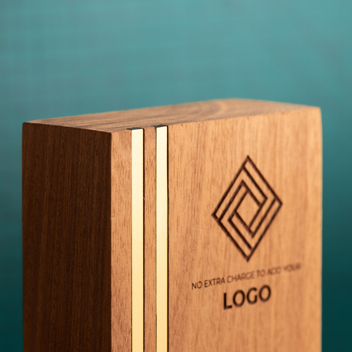 Angled close-up of a Kingdom trophy showing the two parallel gold metallic inlays running vertically near the left edge, with the thickness and natural grain of the wooden block visible.