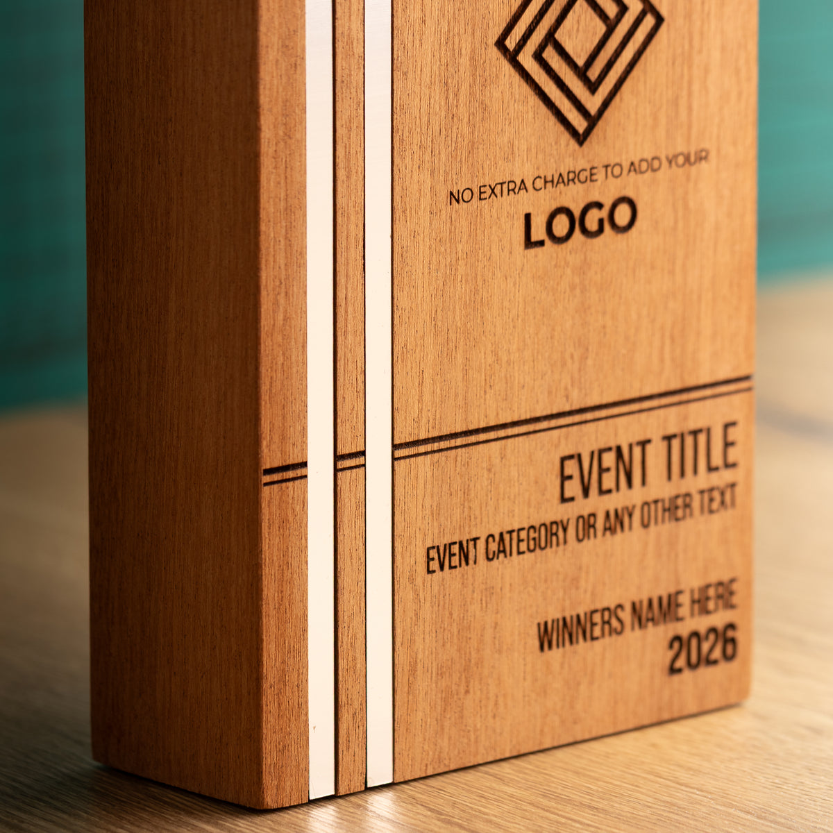 Close-up of the lower-left front of a Kingdom wooden trophy, showing two full-height silver metallic inlays set flush into the wood and crossed by a horizontal engraved line.
