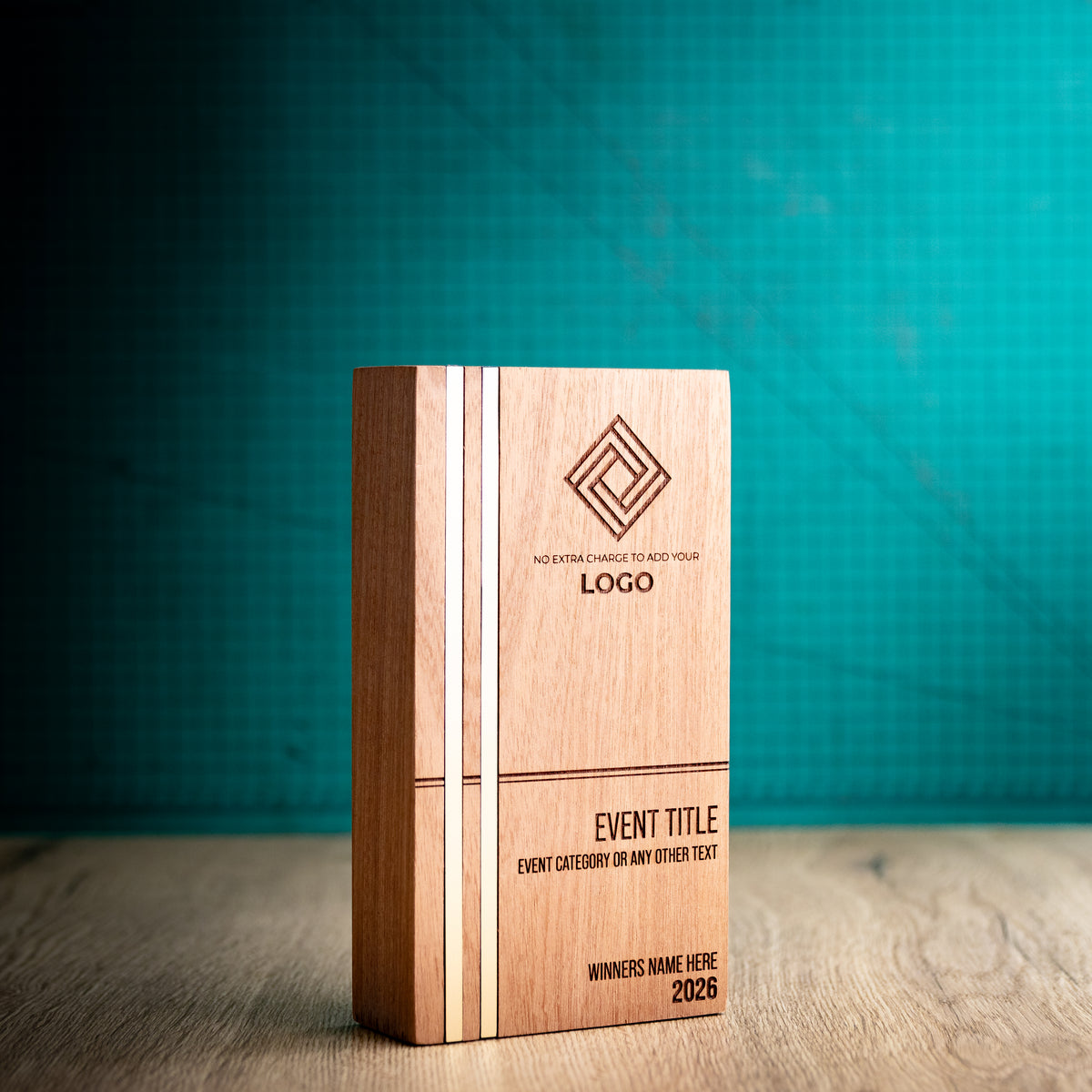 Three-quarter view of the large Kingdom wooden trophy showing its depth and rounded vertical edges, with two full-height gold metallic inlays flush with the left side of the engraved front face.