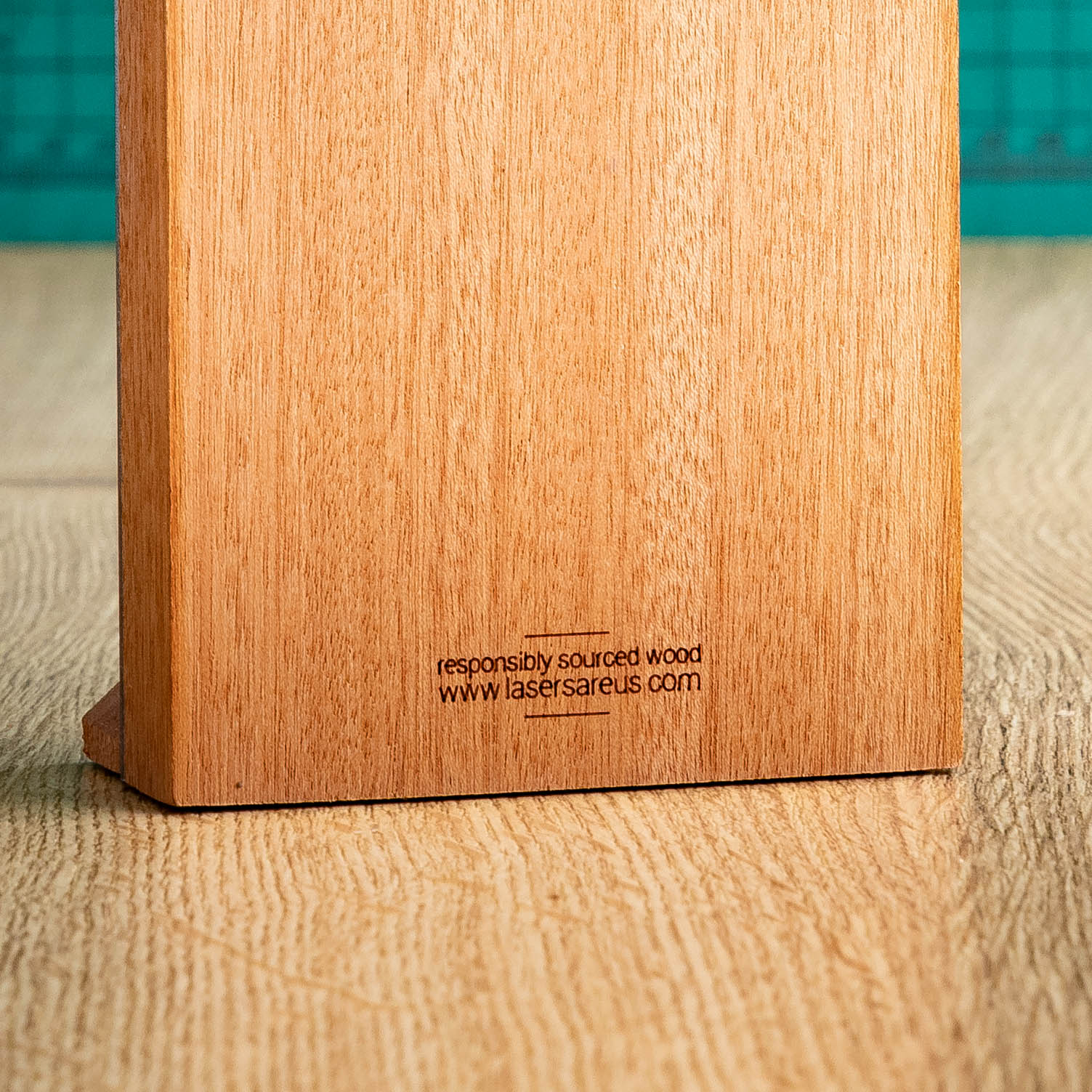 An Eco-friendly wooden trophy with 'responsibly sourced wood' text and www.lasersareus.com on a wooden surface.