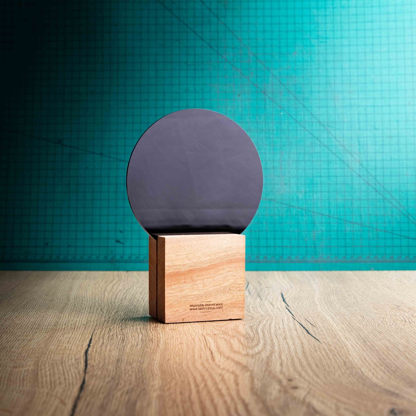 The back of the Legacy Award, an Eco-friendly wooden trophy with 'responsibly sourced wood' text and www.lasersareus.com on a wooden surface.