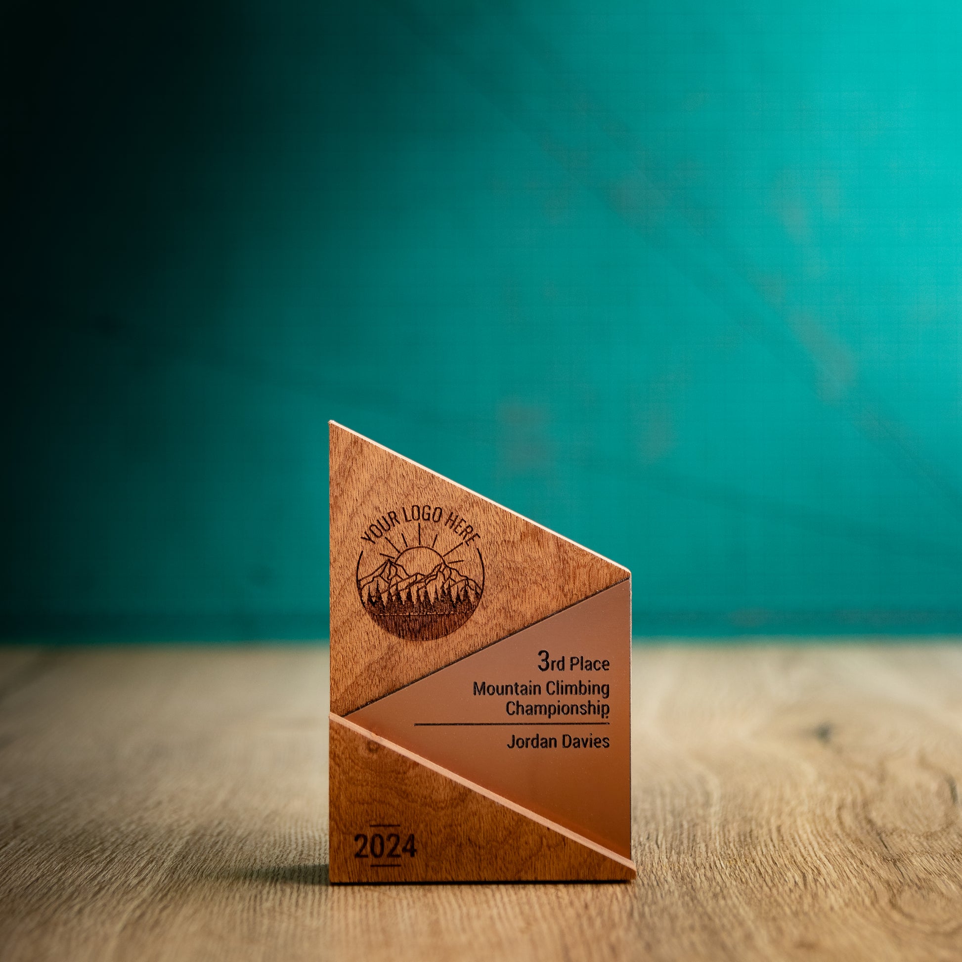 A Small Metallic Peak Trophy. An eco-friendly personalised wooden trophy with a bronze acrylic accent. A Triangular wooden trophy laser-engraved with a logo and trophy personalisation.