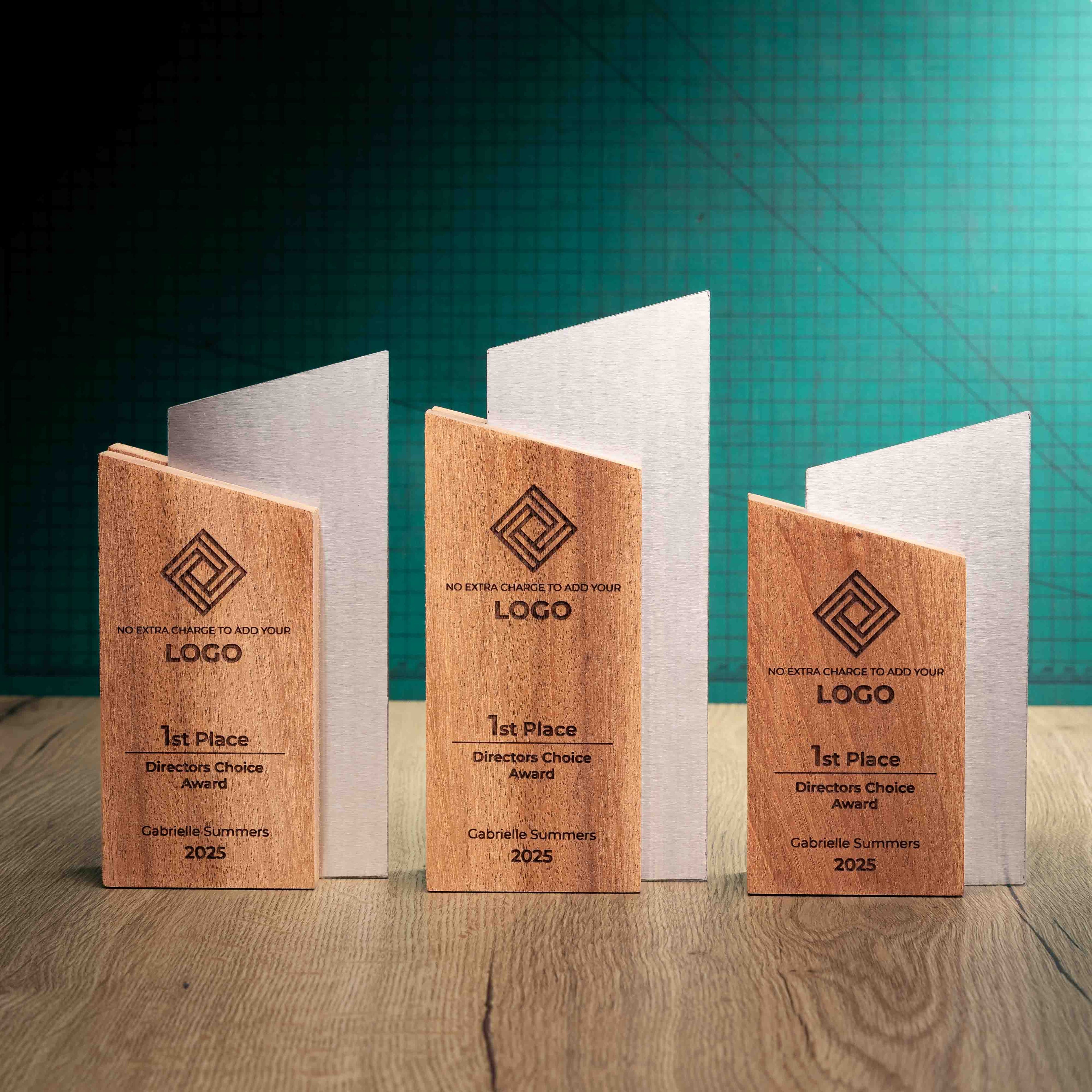 Three eco-friendly wooden and metal Trophies called Monach, group photo. A trophy with a wooden block of sustainably sourced Sapele wood paired with precision-cut stainless steel.