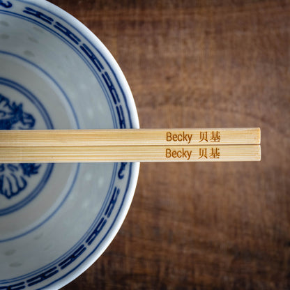 A personalised pair of bamboo chopsticks laser engraved with a name in English and Chinese