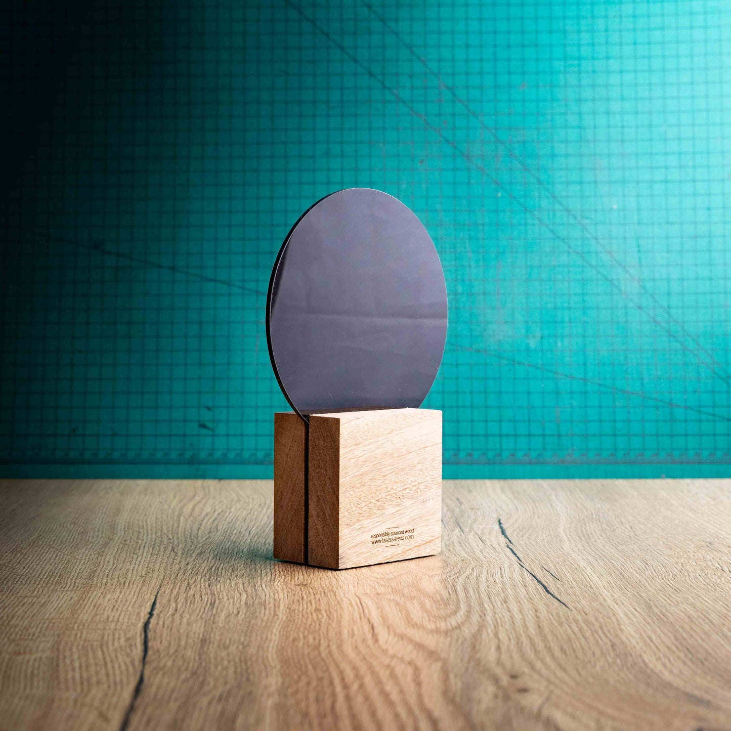 A back view of a medium Netball trophy with custom text and logos, on an eco-friendly wooden base, with a black Perspex Netball mounted on top, featuring fully customisable areas for text and logos.