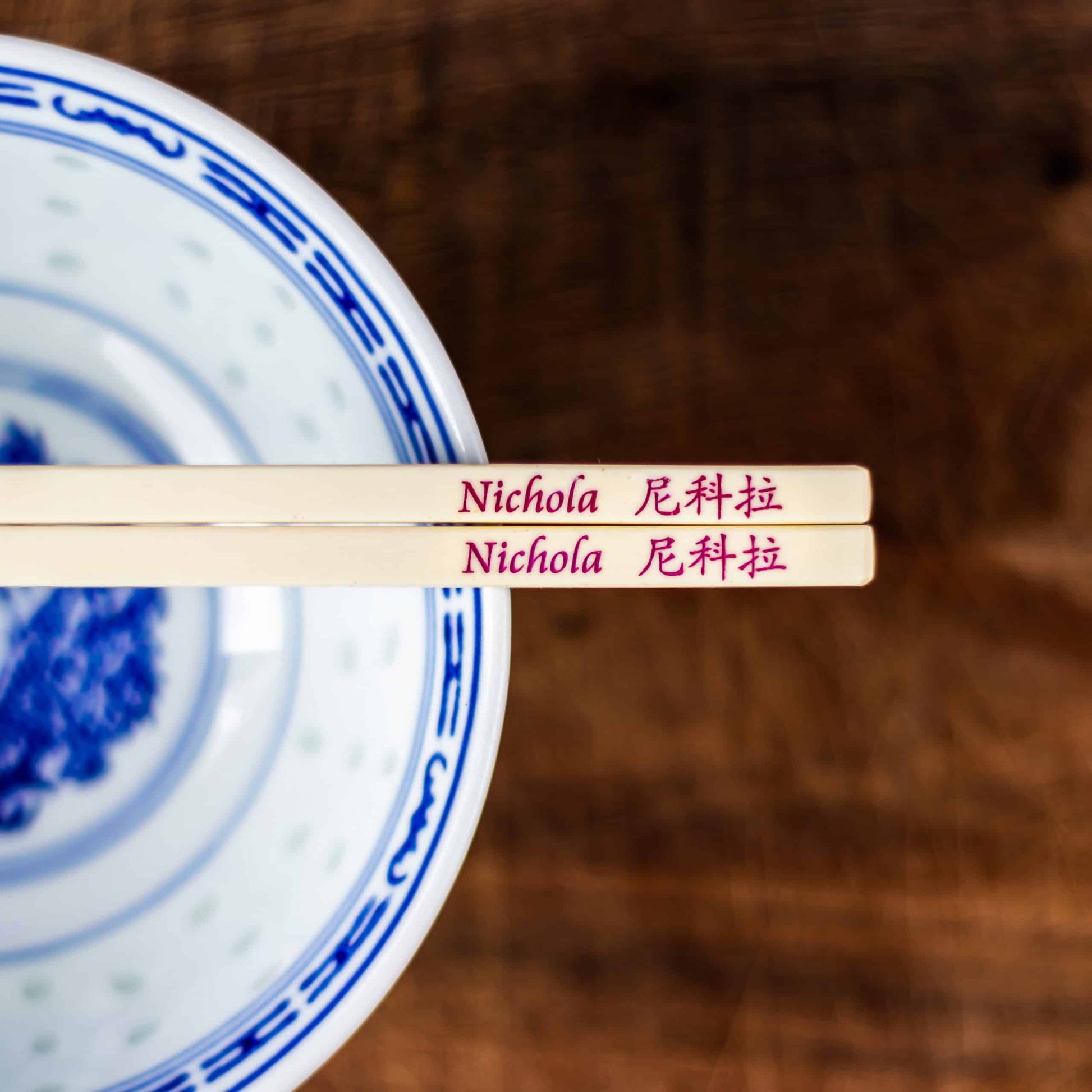 A personalised pair of Plastic Chopsticks that are laser engraved and filled with a colour ink inlay with a name in English and translated into Chinese.