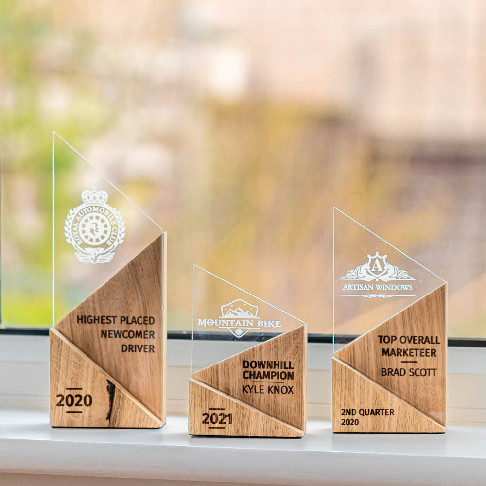 Small, medium and large personalised laser-engraved perspex trophies with an eco-friendly wooden base.