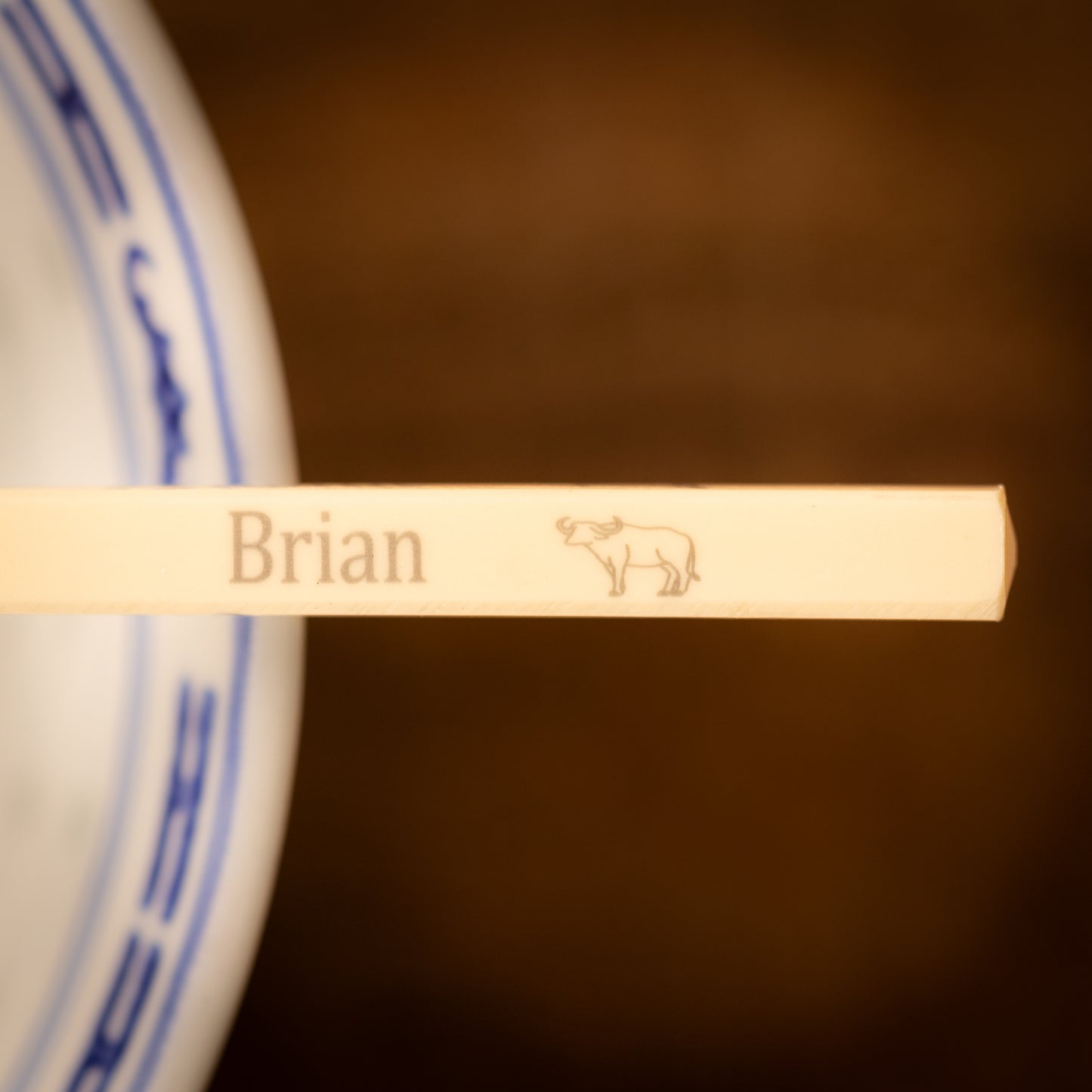 Cream coloured plastic melamine personalised chopsticks engraved with a name and Chinese Zodiac Animal, The Year of the Bull.