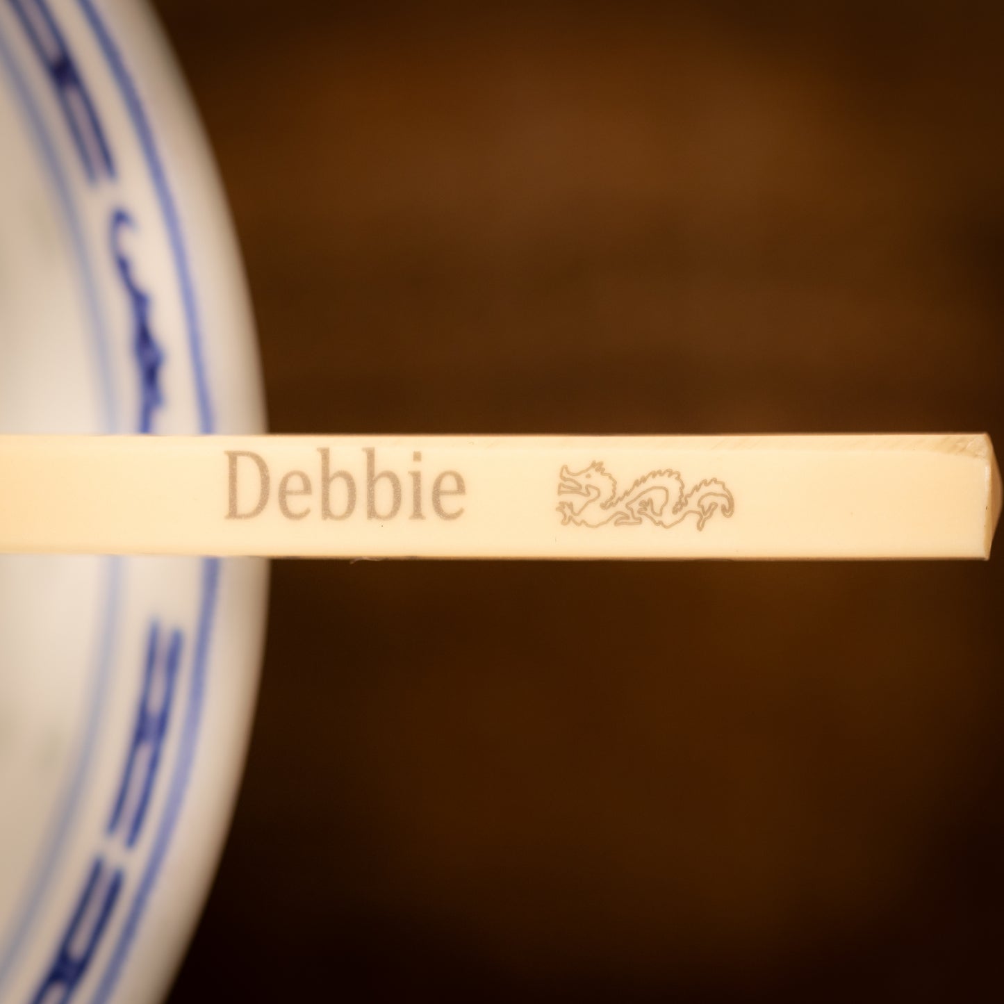 Cream coloured plastic melamine personalised chopsticks engraved with a name and Chinese Zodiac Animal, The Year of the Dragon.