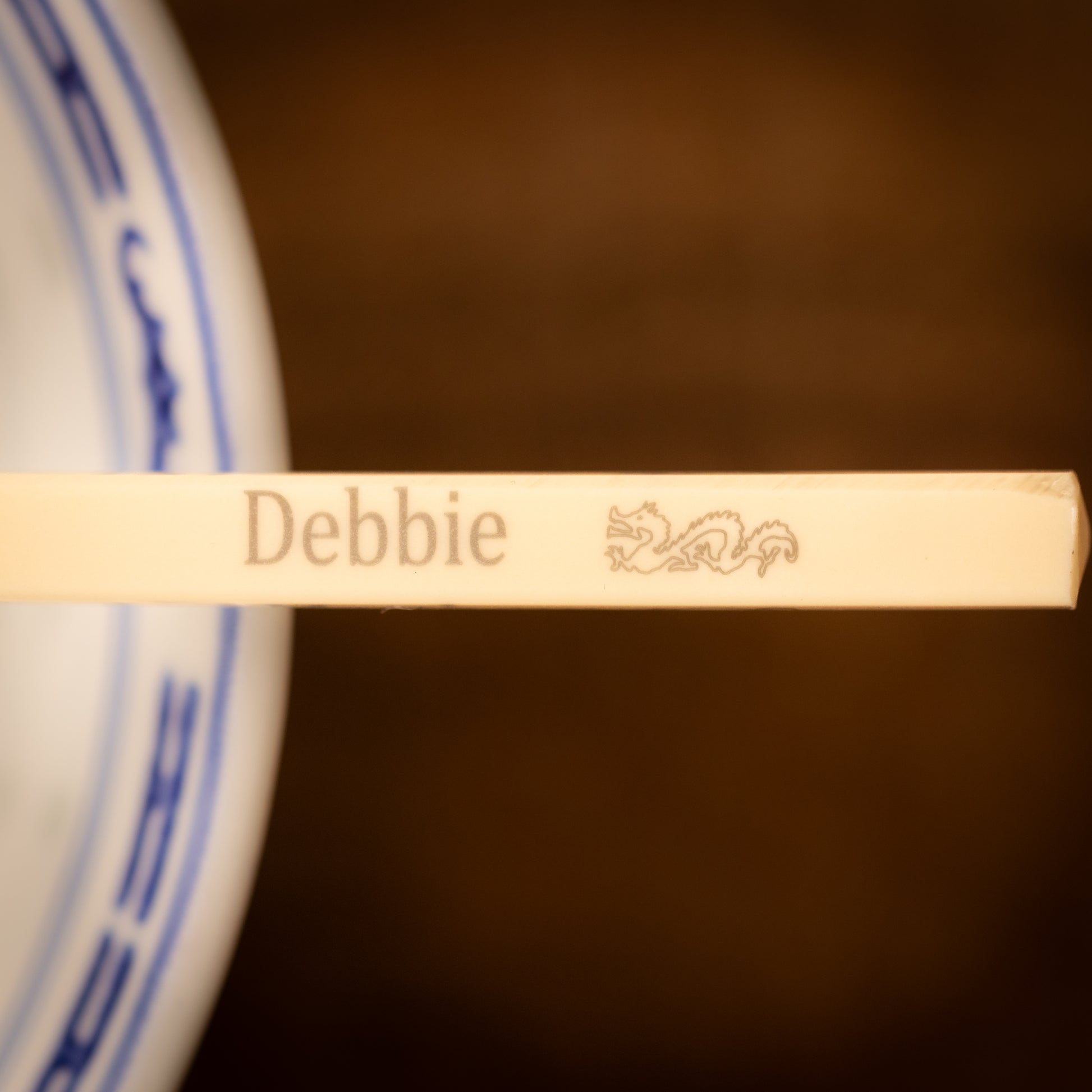 Cream coloured plastic melamine personalised chopsticks engraved with a name and Chinese Zodiac Animal, The Year of the Dragon.