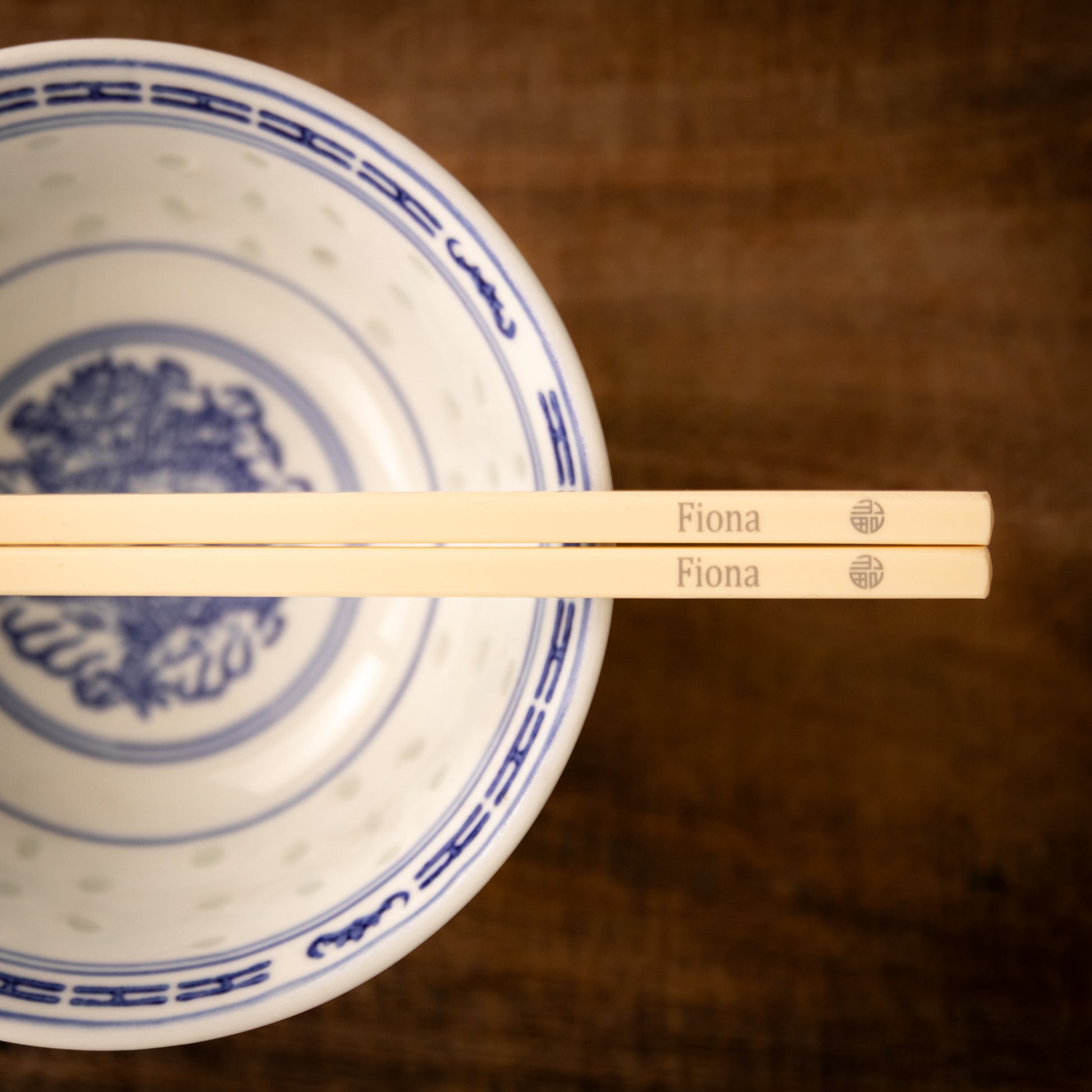 Cream coloured plastic melamine personalised chopsticks engraved with a name and the Chinese symbol Fu in a circular pattern.