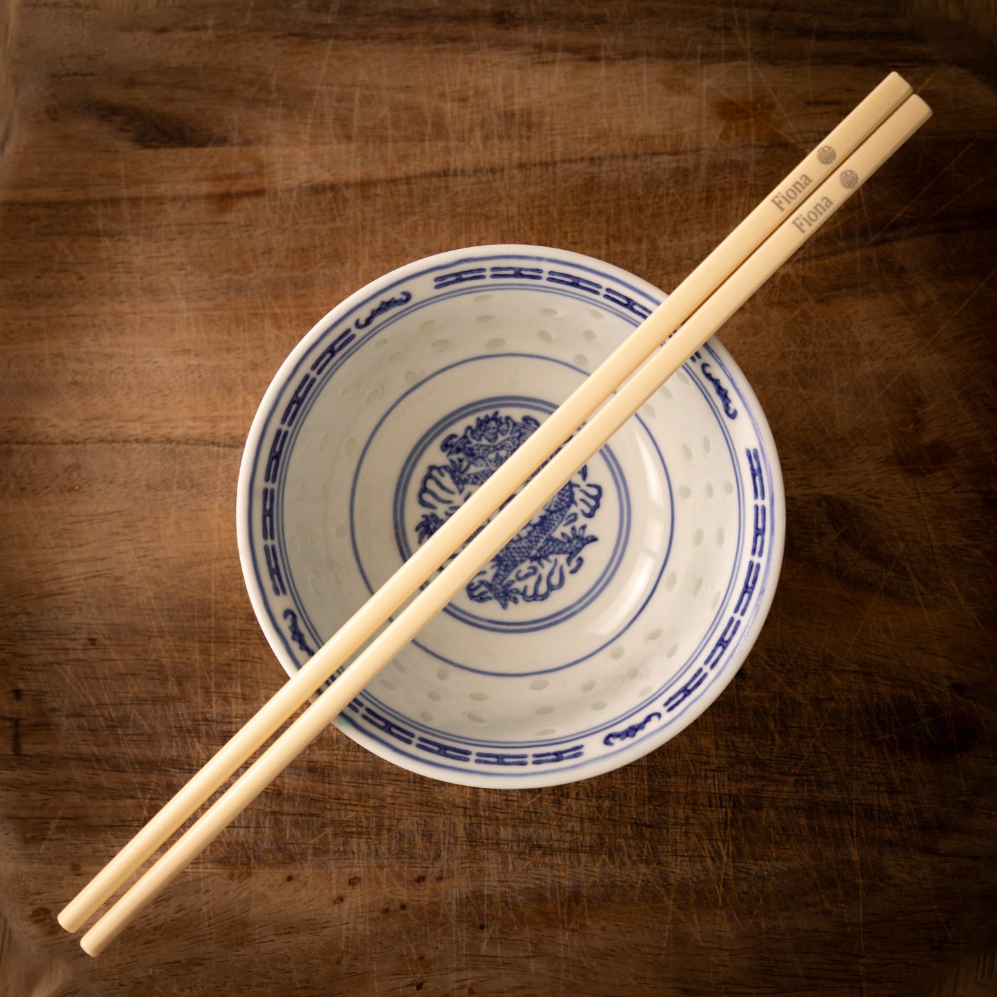 Cream coloured plastic melamine personalised chopsticks engraved with a name and the Chinese symbol Fu in a circular pattern.