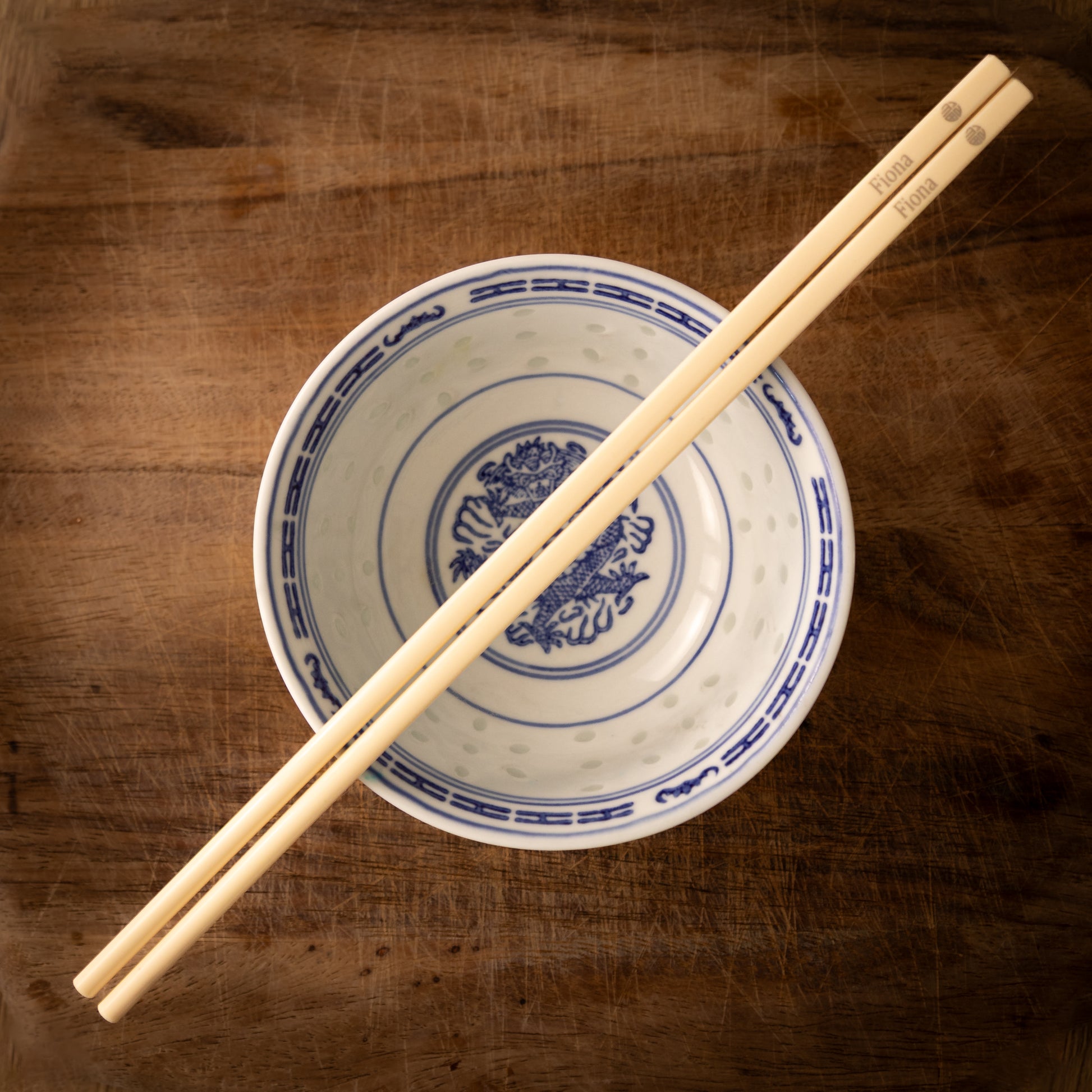 Cream coloured plastic melamine personalised chopsticks engraved with a name and the Chinese symbol Fu in a circular pattern.