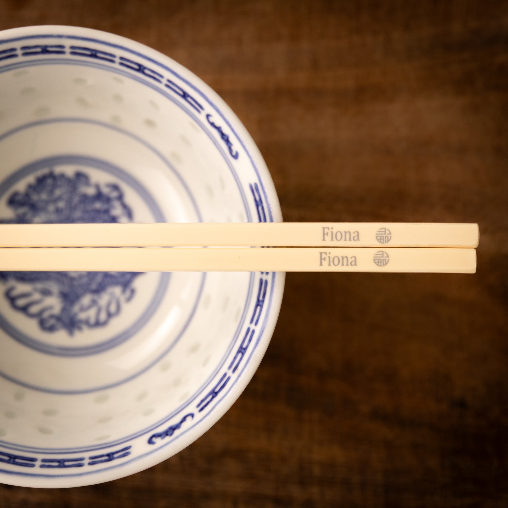 Cream coloured plastic melamine personalised chopsticks engraved with a name and the Chinese symbol Fu in a circular pattern.