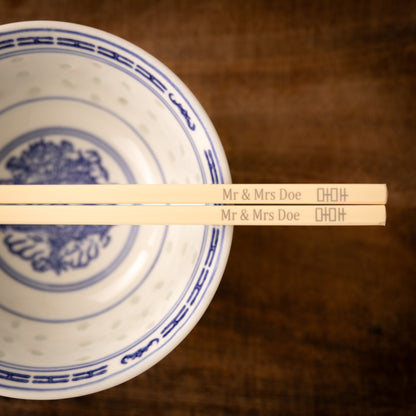 Cream coloured plastic melamine personalised chopsticks engraved for a wedding with a "Mr & Mrs Doe" and the Chinese symbol for double happiness.