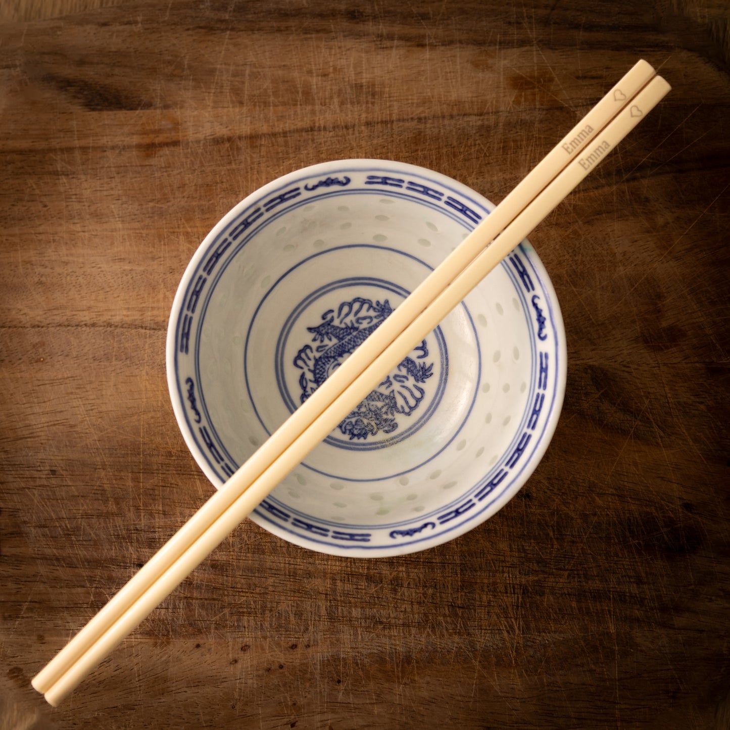 Cream coloured plastic melamine personalised chopsticks engraved with a name and a heart.