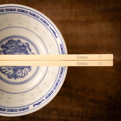 Cream coloured plastic melamine personalised chopsticks engraved with a name and a heart.