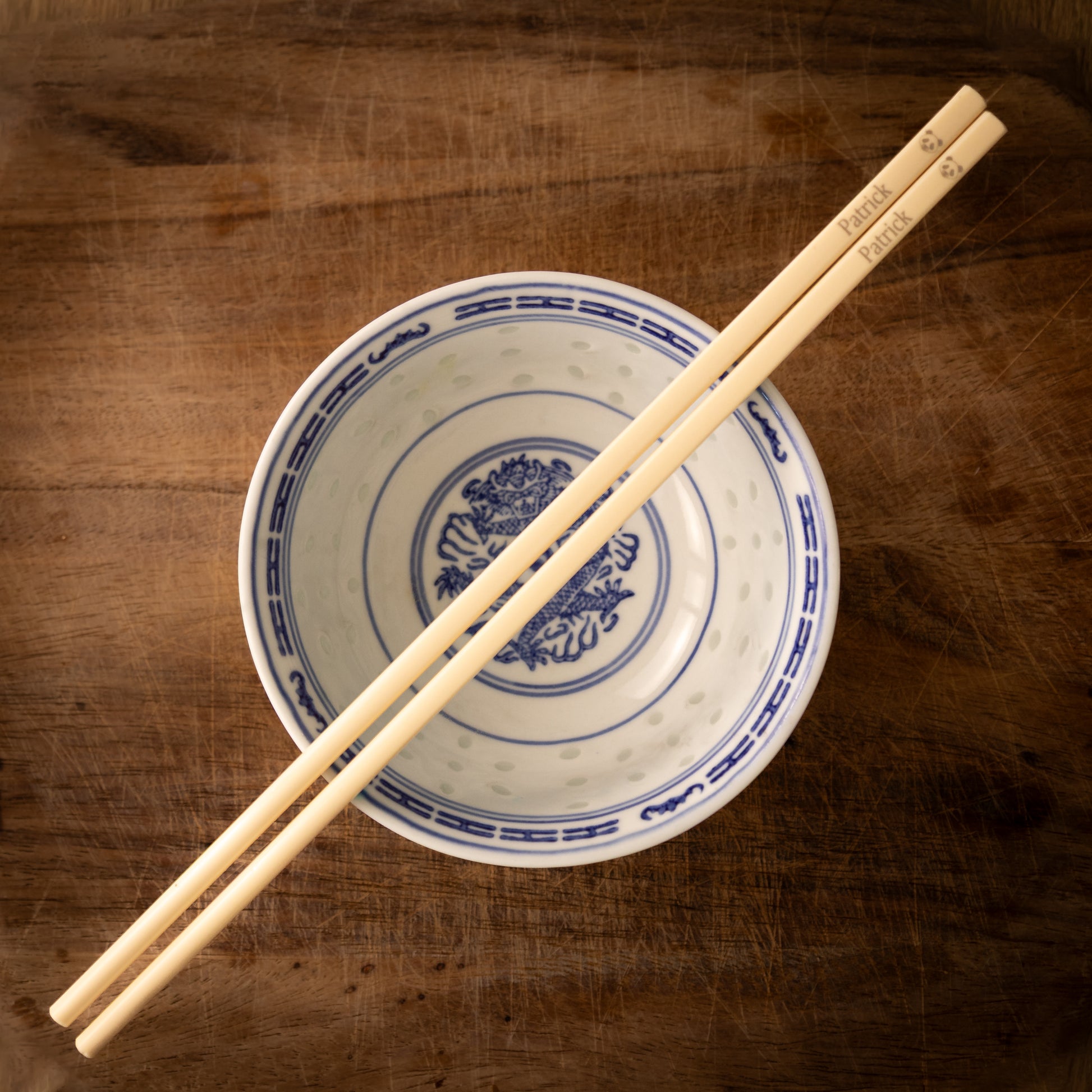 Cream coloured plastic melamine personalised chopsticks engraved with a name and a Panda face.