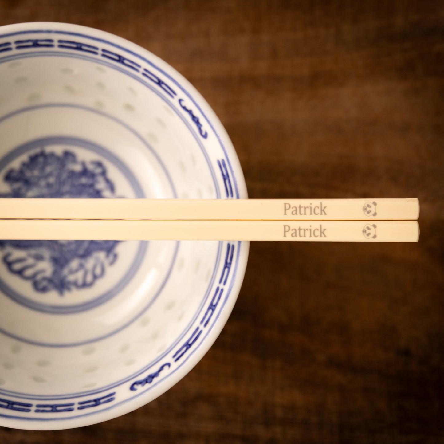 Cream coloured plastic melamine personalised chopsticks engraved with a name and a Panda face.