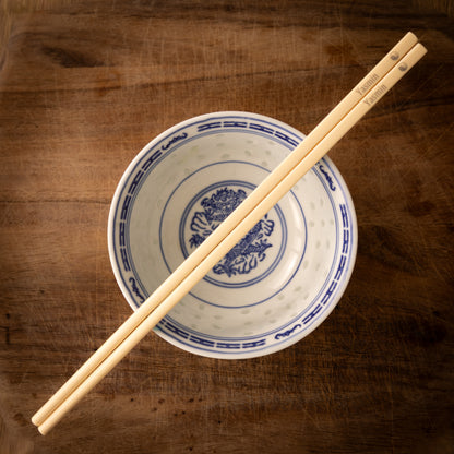 Cream coloured plastic melamine personalised chopsticks engraved with a name and the Ying Yang symbol.