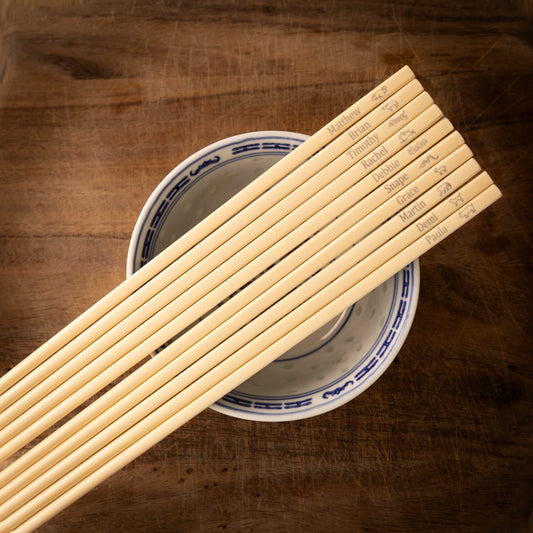 Cream coloured plastic melamine personalised chopsticks engraved with a name and Chinese Zodiac Animals.