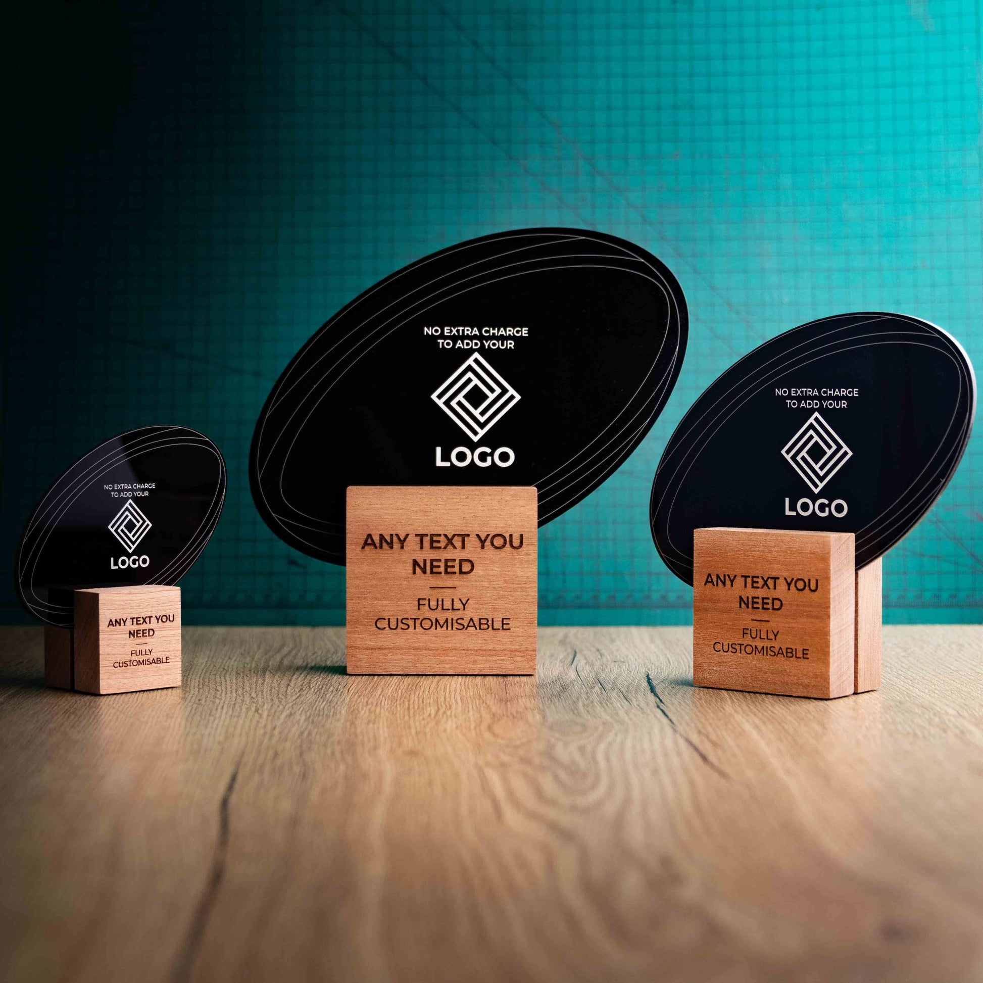 Three rugby trophies with custom text and logos, on eco-friendly wooden bases, with a black Perspex rugby ball mounted on top, featuring fully customisable areas for text and logos.
