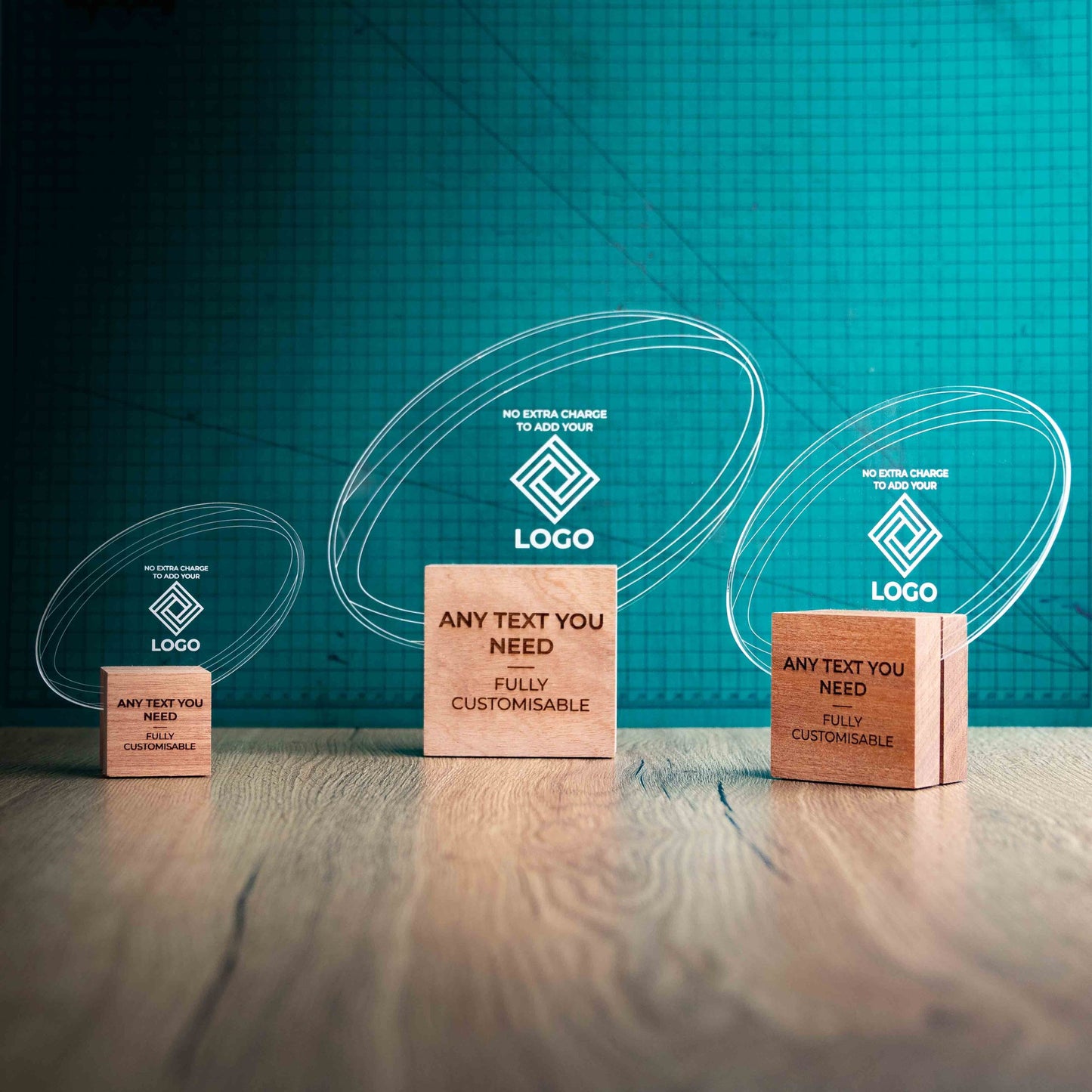 Three rugby trophies with custom text and logos, on eco-friendly wooden bases, with a clear Perspex rugby ball mounted on top, featuring fully customisable areas for text and logos