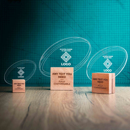Three rugby trophies with custom text and logos, on eco-friendly wooden bases, with a clear Perspex rugby ball mounted on top, featuring fully customisable areas for text and logos