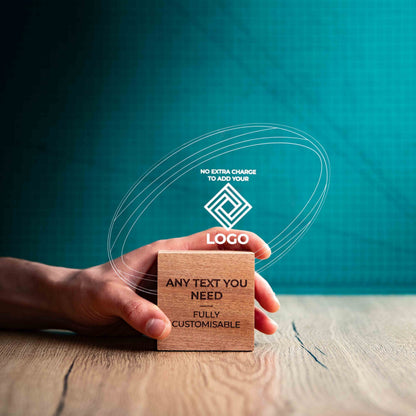 A hand holding a medium rugby award with custom text and logos, on an eco-friendly wooden base, with a clear Perspex rugby ball mounted on top, featuring fully customisable areas for text and logos.