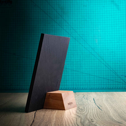 A side angle of a Medium Solet Award, an eco-friendly, wooden and slate trophy. The Solet Award has a base made of two wooden pieces on either side of a square piece of Welsh Slate. The trophy is personalised with Event information and a logo. 