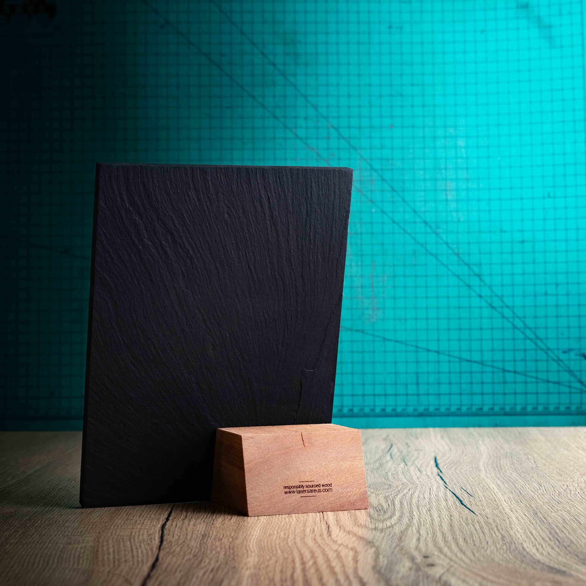 The back of the Solet Award, an Eco-friendly wooden and slate trophy with 'responsibly sourced wood' text and www.lasersareus.com on a wooden surface.