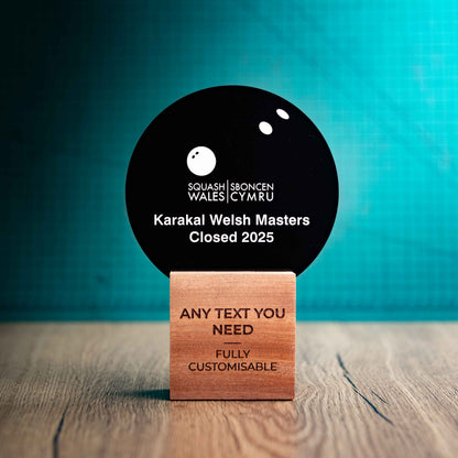 A medium Squash trophy with custom text and logos, on an eco-friendly wooden base, with a black Perspex Squash ball mounted on top, featuring fully customisable areas for text and logos.