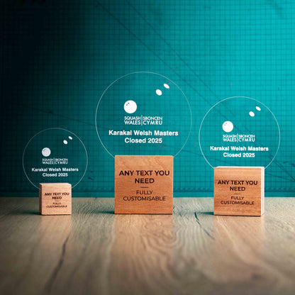 Three squash trophies with custom text and logos, on eco-friendly wooden bases, with a clear Perspex squash ball mounted on top, featuring fully customisable areas for text and logos.