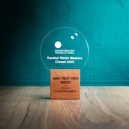 A large Squash trophy with custom text and logos, on an eco-friendly wooden base, with a clear Perspex Squash ball mounted on top, featuring fully customisable areas for text and logos.
