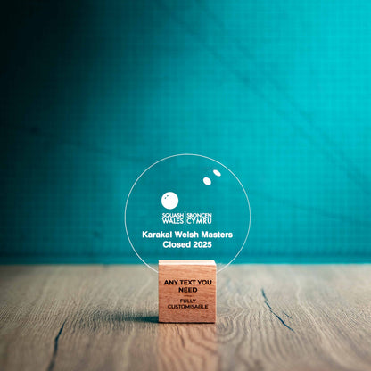 A small Squash trophy with custom text and logos, on an eco-friendly wooden base, with a clear Perspex Squash ball mounted on top, featuring fully customisable areas for text and logos.