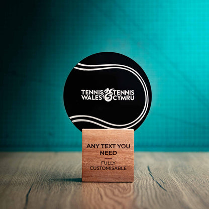 A medium Tennis trophy with custom text and logos, on an eco-friendly wooden base, with a black Perspex Tennis ballmounted on top, featuring fully customisable areas for text and logos.