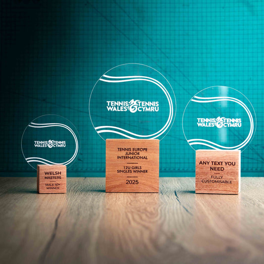 Three Tennis trophies with custom text and logos, on eco-friendly wooden bases, with a clear Perspex Tennis Ball mounted on top, featuring fully customisable areas for text and logos.