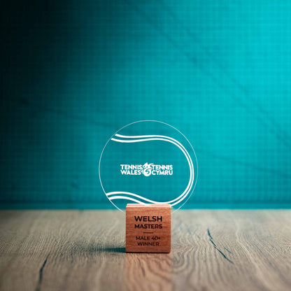 A small Tennis trophy with custom text and logos, on an eco-friendly wooden base, with a clear Perspex Tennis ballmounted on top, featuring fully customisable areas for text and logos.