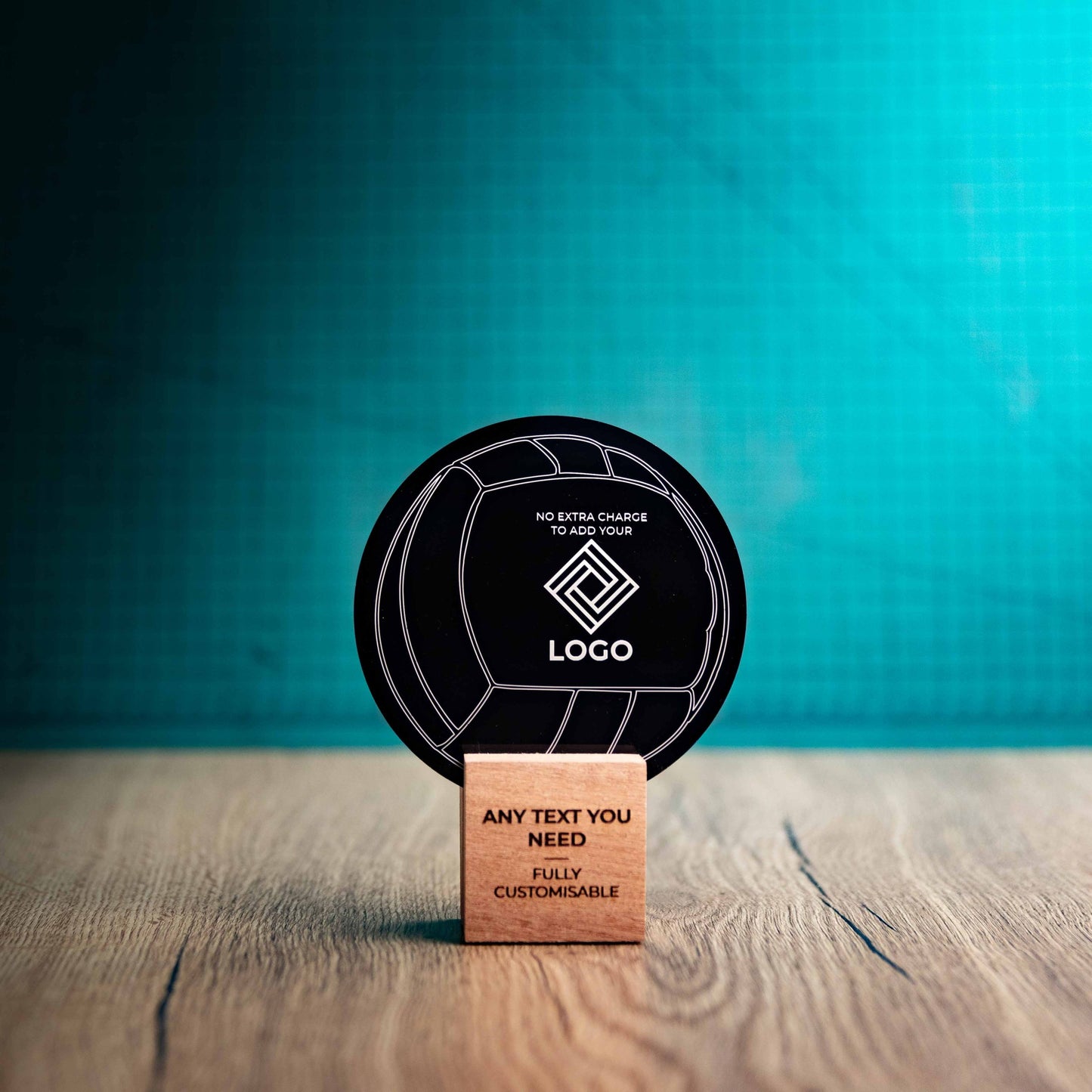 A small Valleyball trophy with custom text and logos, on an eco-friendly wooden base, with a black Perspex Volleyball mounted on top, featuring fully customisable areas for text and logos.