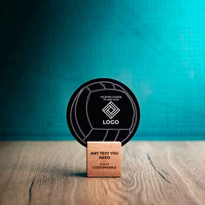 A small Valleyball trophy with custom text and logos, on an eco-friendly wooden base, with a black Perspex Volleyball mounted on top, featuring fully customisable areas for text and logos.