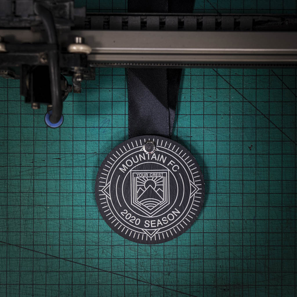 A personalised laser engraved Welsh slate running medal