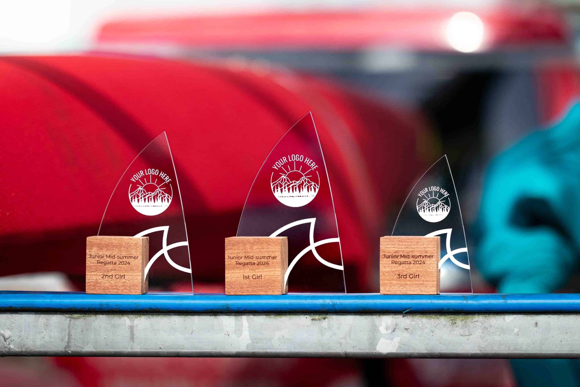 Three Windward Awards, Eco-Friendly Wooden Trophies with recycled perspex, sat next to canoes in the sun