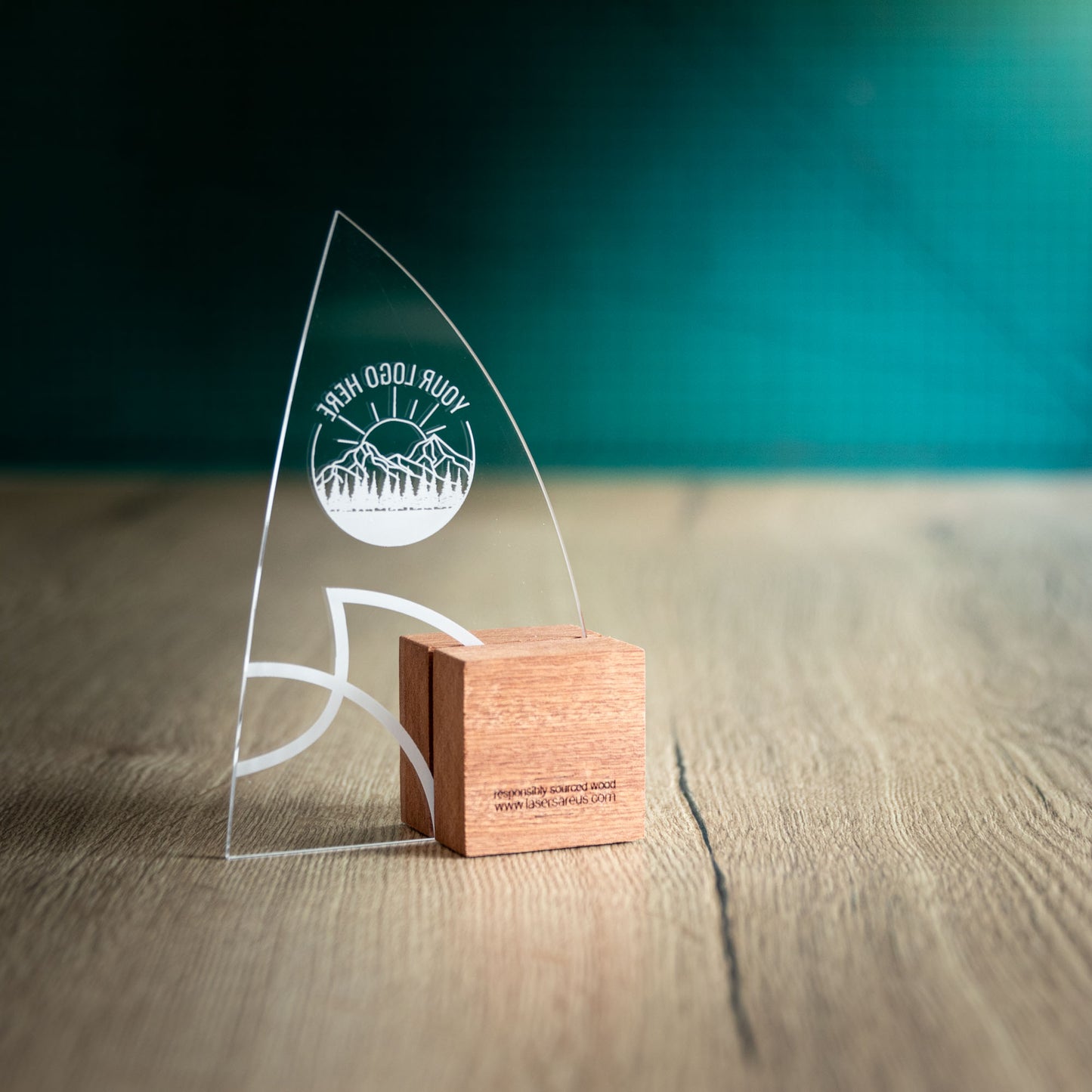 The back of the Windward Award, an Eco-friendly wooden trophy with 'responsibly sourced wood' text and www.lasersareus.com on a wooden surface.