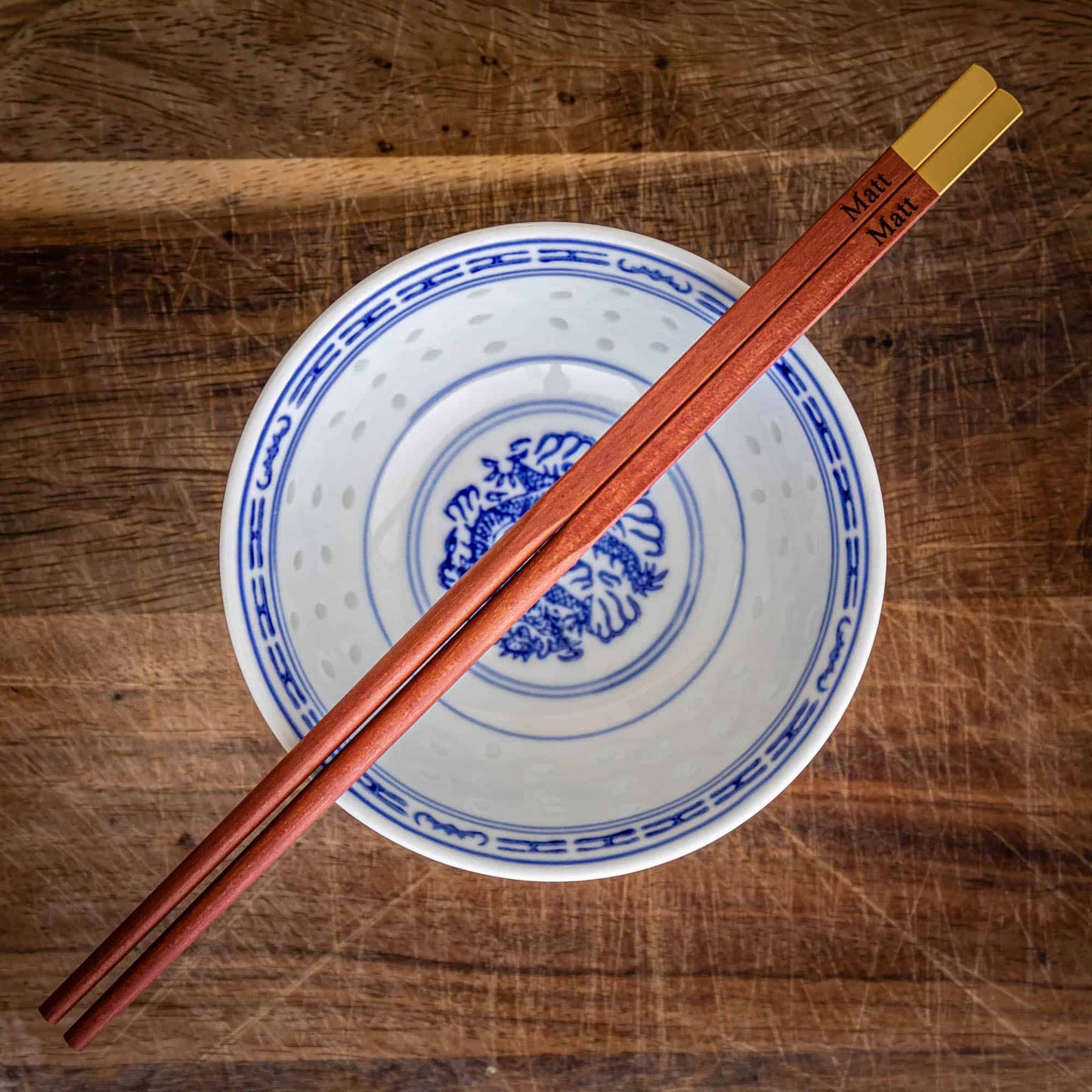 A pair of personalised Metallic Ended Dark Wooden Chopsticks laser engraved with a name of your choice