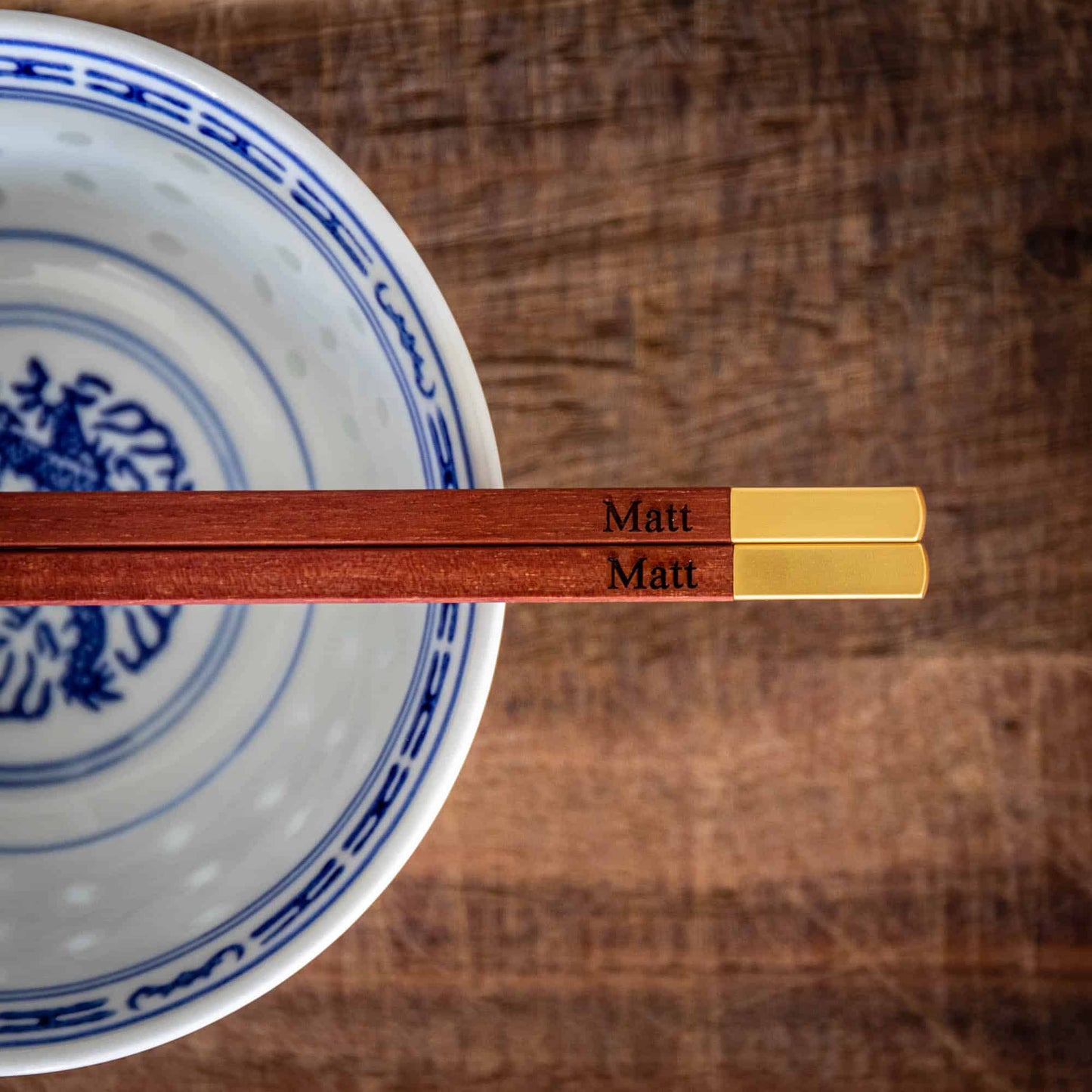 A pair of personalised Metallic Ended Dark Wooden Chopsticks laser engraved with a name of your choice