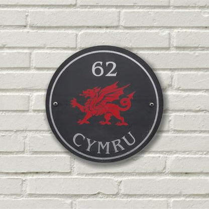 A circular Welsh Slate House Plaque with a color filled house number, welsh dragon and a boarder
