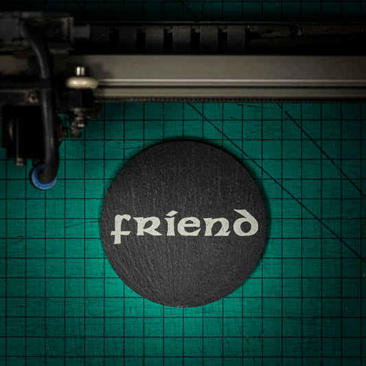 A Welsh slate coaster laser engraved with the word friend